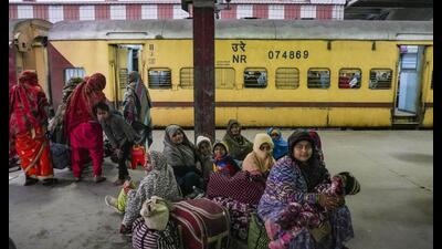 People wait for trains at Charbagh railway station during a cold winter evening, in Lucknow, Wednesday. Multiple trains were delayed due to fog. (PTI Photo)