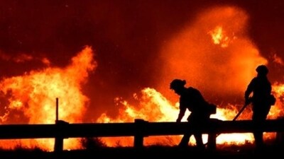 The sole route into and out of her neighbourhood was totally closed, according to resident Kelsey Trainor. Fires blazed on both sides of the road, and ash rained everywhere. (Reuters Photo)
