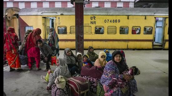 People wait for trains at Charbagh railway station during a cold winter evening, in Lucknow, Wednesday. Multiple trains were delayed due to fog. (PTI Photo)
