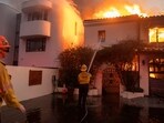 Firefighters battle the Palisades fire as it burns during a windstorm on the west side of Los Angeles, California