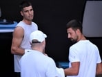 Spain's Carlos Alcaraz (L) chats with Novak Djokovic of Serbia (R) during a training session ahead of the Australian Open tennis tournament in Melbourne on January 7, 2025. Spain's Carlos Alcaraz (L) chats with Novak Djokovic of Serbia (R) during a training session ahead of the Australian Open tennis tournament in Melbourne on January 7, 2025.