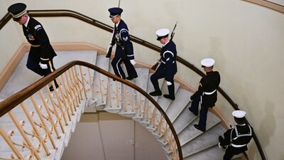 Members of the Honor Guard ascend a staircase to replace other members keeping watch over the flag-draped casket of Jimmy Carter (REUTERS)