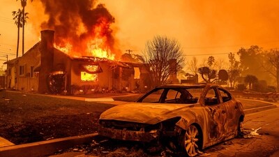The carcass of a burnt-out car is seen as home burns during the Eaton fire in the Altadena area of Los Angeles County, As the fire approached key roads, including Sunset Boulevard, many drivers were told by fire officials to abandon their vehicles and flee. (AFP) The carcass of a burnt-out car is seen as home burns during the Eaton fire in the Altadena area of Los Angeles County, As the fire approached key roads, including Sunset Boulevard, many drivers were told by fire officials to abandon their vehicles and flee. (AFP)