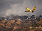 An aircraft flies over areas affected by the Palisades Fire in Pacific Palisades, California, U.S. January 9, 2025. 