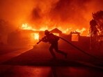 A firefighter battles the Palisades Fire as it burns a structure in the Pacific Palisades neighborhood of Los Angeles. A firefighter battles the Palisades Fire as it burns a structure in the Pacific Palisades neighborhood of Los Angeles.