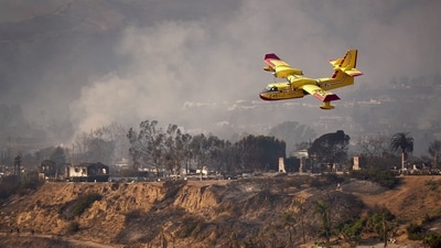 An aircraft flies over areas affected by the Palisades Fire in Pacific Palisades, California, U.S. January 9, 2025. (REUTERS/Nathan Frandino)