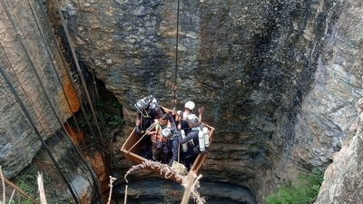 Divers use a pulley to enter a coal mine to rescue trapped miners in Umrangso, a remote area in the northeastern state of Assam (REUTERS)