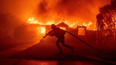A firefighter battles the Palisades Fire as it burns a structure in the Pacific Palisades neighborhood of Los Angeles. (AP) A firefighter battles the Palisades Fire as it burns a structure in the Pacific Palisades neighborhood of Los Angeles. (AP)