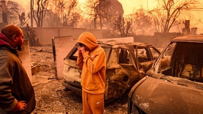 Lebron Jones (C) wipes his eyes while viewing his burned home during the Eaton fire in the Altadena area of Los Angeles county, California. More than 1,000 buildings have burned in multiple wildfires that have erupted around America's second biggest city, forcing tens of thousands of people from their homes. (Josh Edelson/AFP) Lebron Jones (C) wipes his eyes while viewing his burned home during the Eaton fire in the Altadena area of Los Angeles county, California. More than 1,000 buildings have burned in multiple wildfires that have erupted around America's second biggest city, forcing tens of thousands of people from their homes. (Josh Edelson/AFP)