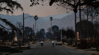Residents walk down a street lined with the charred remnants of homes destroyed by the Eaton Fire in Altadena, California, on January 9, 2025. The Palisades and Eaton fires, the two largest blazes, created a massive pincer around Los Angeles visible from space. Pacific Palisades was left in ruins, with former luxury homes destroyed, power lines downed, and abandoned vehicles scattered across streets. (AFP) Residents walk down a street lined with the charred remnants of homes destroyed by the Eaton Fire in Altadena, California, on January 9, 2025. The Palisades and Eaton fires, the two largest blazes, created a massive pincer around Los Angeles visible from space. Pacific Palisades was left in ruins, with former luxury homes destroyed, power lines downed, and abandoned vehicles scattered across streets. (AFP)
