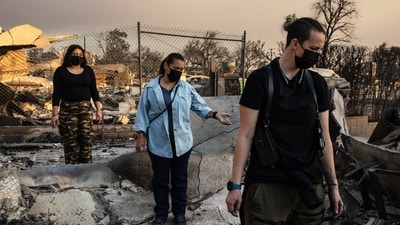 People look through the charred ruins of their home burned in the Eaton Fire in Altadena, California, January 9, 2025. Massive wildfires that engulfed whole neighborhoods and displaced thousands in Los Angeles remained totally uncontained January 9, 2025, (AFP)