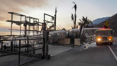 Firefighters tackle lingering hot spots at a house reduced to ashes by the Palisades Fire along the Pacific Coast Highway in Malibu, California, on January 9, 2025. Crews successfully contained the Sunset Fire in the Hollywood Hills, which had threatened the iconic Walk of Fame on Wednesday night. (AFP) Firefighters tackle lingering hot spots at a house reduced to ashes by the Palisades Fire along the Pacific Coast Highway in Malibu, California, on January 9, 2025. Crews successfully contained the Sunset Fire in the Hollywood Hills, which had threatened the iconic Walk of Fame on Wednesday night. (AFP)