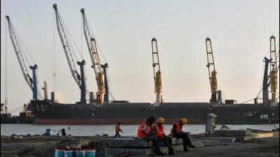 Workers rest in front of a cargo ship at Mundra port in Gujarat. (Reuters File Photo)