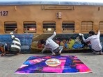 Ahmedabad: Railway workers paste posters on the exteriors of a Kumbh Mela special train, which will leave for Prayagraj, at a railway yard in Ahmedabad. (File image) Ahmedabad: Railway workers paste posters on the exteriors of a Kumbh Mela special train, which will leave for Prayagraj, at a railway yard in Ahmedabad. (File image)