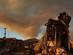 The Palisades Fire continues to burn above the remains of Community United Methodist Church, with a police helicopter flying past as wildfires cause damage and loss through Los Angeles County on January 10, 2025 in Pacific Palisades, California. 