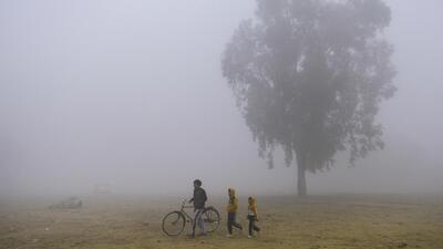 A man and children brave a foggy winter morning in Jalandhar on Saturday. (PTI) A man and children brave a foggy winter morning in Jalandhar on Saturday. (PTI)