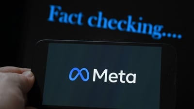 This photo illustration created on January 8, 2025, in Brussels, shows the media giant Meta's logo displayed on a smartphone and screen displaying the words "fact checking". (Photo by Nicolas TUCAT / AFP) (AFP)