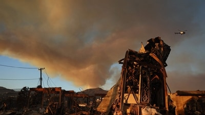 The Palisades Fire continues to burn above the remains of Community United Methodist Church, with a police helicopter flying past as wildfires cause damage and loss through Los Angeles County on January 10, 2025 in Pacific Palisades, California. (Getty Images via AFP) The Palisades Fire continues to burn above the remains of Community United Methodist Church, with a police helicopter flying past as wildfires cause damage and loss through Los Angeles County on January 10, 2025 in Pacific Palisades, California. (Getty Images via AFP)