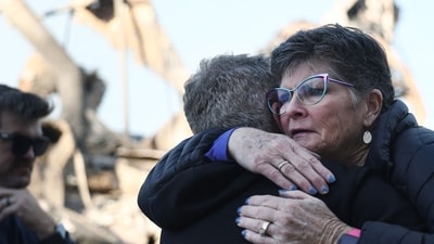 Pacific Palisades Fire: A supporter (R) hugs Rev. John Shaver after he visited the remains of Community United Methodist Church, where he is pastor, as wildfires cause damage and loss through Los Angeles County on January 10, 2025 in Pacific Palisades, California. (Mario Tama/Getty Images/AFP)