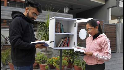 Youngsters picking books of their interest from the mini library in Dugri. (HT Photo)