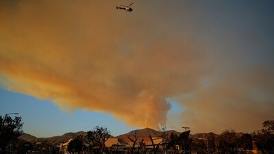 5. The series of fires started spreading on Tuesday, driven by dry strong winds called 'Santa Ana. In pic: A police helicopter flies over burned areas following the Palisades Fire at the Pacific Palisades neighborhood, as smoke from the Palisades Fire rises, in Los Angeles, California,&nbsp; (REUTERS)