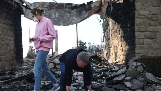 Pacific Palisades Fire: Rev. John Shaver carries away a section of the baptismal font after looking through the remains of Community United Methodist Church, while visiting for the first time since it was destroyed in the Palisades Fire, as wildfires cause damage and loss through Los Angeles County on January 10, 2025 in Pacific Palisades, California.(Mario Tama/Getty Images/AFP)