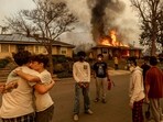 Residents embrace outside of a burning property as the Eaton Fire swept through. Residents embrace outside of a burning property as the Eaton Fire swept through.