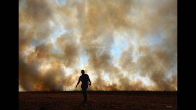 (FILES) A man is seen in front of smoke rising from an illegally lit fire on a maize field that borders a rainforest reserve, in Sinop, Mato Grosso state, Brazil, on August 9, 2020. . (Photo by CARL DE SOUZA / AFP) (AFP) (FILES) A man is seen in front of smoke rising from an illegally lit fire on a maize field that borders a rainforest reserve, in Sinop, Mato Grosso state, Brazil, on August 9, 2020. . (Photo by CARL DE SOUZA / AFP) (AFP)