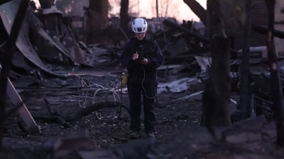 Jennifer McCullough from Marin County Search and Rescue inspects a burned property for potential hazards and remains during the Eaton Fire in Altadena, California, U.S. On Friday, Governor Gavin Newsom ordered an investigation into the failure of a 117-million-gallon reservoir and the drying up of hydrants. (REUTERS)