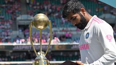 Jasprit Bumrah looks at his Player of the Series award for the Border-Gavaskar Trophy. (AFP)
