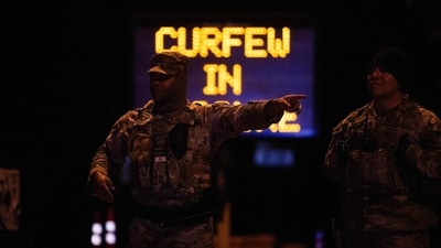 National Guard officers close off streets, enforcing a curfew in evacuation and warning zones during the wildfires. On Saturday, a fierce firefight unfolded in Mandeville Canyon, where helicopters dropped water on the flames as they spread downhill near celebrity homes, including Arnold Schwarzenegger’s. (Getty Images via AFP) National Guard officers close off streets, enforcing a curfew in evacuation and warning zones during the wildfires. On Saturday, a fierce firefight unfolded in Mandeville Canyon, where helicopters dropped water on the flames as they spread downhill near celebrity homes, including Arnold Schwarzenegger’s. (Getty Images via AFP)