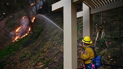 A firefighter works to extinguish flames in the Mandeville Canyon neighborhood of Los Angeles, California, on January 11, 2025, as the Palisades Fire continues to spread. The fire, the largest in Los Angeles, advanced toward previously untouched areas, prompting new evacuations and raising concerns about control over the disaster. (AFP) A firefighter works to extinguish flames in the Mandeville Canyon neighborhood of Los Angeles, California, on January 11, 2025, as the Palisades Fire continues to spread. The fire, the largest in Los Angeles, advanced toward previously untouched areas, prompting new evacuations and raising concerns about control over the disaster. (AFP)
