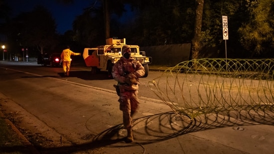 A National Guard officer enforces a curfew from 6:00 pm to 6:00 am in evacuation zones and areas under evacuation warnings in Santa Monica, California, on January 11, 2025, as wildfires cause widespread damage across the Los Angeles region.(Getty Images via AFP)