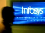 A man walks past a billboard of Infosys Technologies Ltd's office in Bangalore, October 10, 2003.