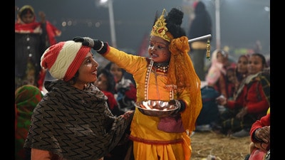 A kid dressed as Lord Krishna giving blessings to the pilgrims at the Sangam in Prayagraj on Monday. (Deepak Gupta/ht photo) A kid dressed as Lord Krishna giving blessings to the pilgrims at the Sangam in Prayagraj on Monday. (Deepak Gupta/ht photo)