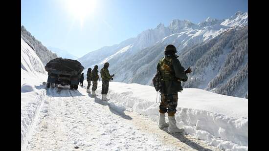 (FILES) Indian army soldiers walk along a road near Zojila mountain pass that connects Srinagar to the union territory of Ladakh, bordering China on February 28, 2021. (Photo by TAUSEEF MUSTAFA / AFP) (AFP)