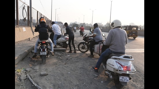 While the Pune Municipal Corporation (PMC) widened one side of the road and constructed footpaths in 2023 after removing encroachments, the other side remains narrow, forcing commuters to jostle for space during peak hours. (HT PHOTO)