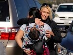 Kara Grewach, right, hugs Silvia, only first name given, while Grewach donated items at an aid centre for people affected by wildfires at Santa Anita Park Monday. Kara Grewach, right, hugs Silvia, only first name given, while Grewach donated items at an aid centre for people affected by wildfires at Santa Anita Park Monday.