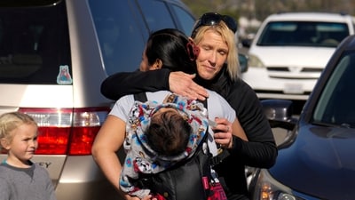 Kara Grewach, right, hugs Silvia, only first name given, while Grewach donated items at an aid centre for people affected by wildfires at Santa Anita Park Monday. (AP) Kara Grewach, right, hugs Silvia, only first name given, while Grewach donated items at an aid centre for people affected by wildfires at Santa Anita Park Monday. (AP)