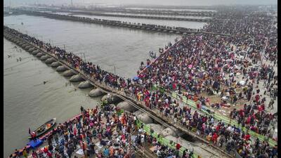 Devotees cross a pontoon bridge at Sangam, the confluence of the Ganga, Yamuna and mythical Saraswati on Makar Sankranti Day during the Mahakumbh in Prayagraj, Tuesday. (AP Photo)