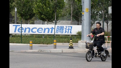 FILE - A man rides past the Tencent headquarters in Beijing, China on Aug. 7, 2020. (AP Photo/Ng Han Guan, File) (AP) FILE - A man rides past the Tencent headquarters in Beijing, China on Aug. 7, 2020. (AP Photo/Ng Han Guan, File) (AP)