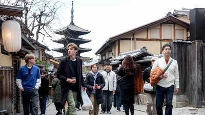 Tourists walk through the streets by Yasaka Pagoda (behind) during a visit to the city of Kyoto. (Photo by PAUL MILLER / AFP) Tourists walk through the streets by Yasaka Pagoda (behind) during a visit to the city of Kyoto. (Photo by PAUL MILLER / AFP)