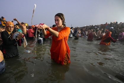 A devotee performs rituals as she takes a holy dip at the Sangam on the occasion of 'Makar Sankranti' festival, during the Maha Kumbh Mela 2025, in Prayagraj, Uttar Pradesh, Tuesday, (PTI) A devotee performs rituals as she takes a holy dip at the Sangam on the occasion of 'Makar Sankranti' festival, during the Maha Kumbh Mela 2025, in Prayagraj, Uttar Pradesh, Tuesday, (PTI)