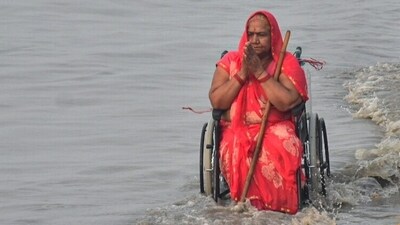 A devotee sitting in a wheelchair takes 'Punnya Snan' (holy bath) on the occasion of 'Makar Sankranti'. (ANI) A devotee sitting in a wheelchair takes 'Punnya Snan' (holy bath) on the occasion of 'Makar Sankranti'. (ANI)