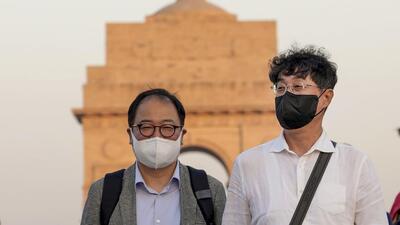 Tourists wear face masks amid smoggy conditions near India Gate in New Delhi. (PTI Photo) Tourists wear face masks amid smoggy conditions near India Gate in New Delhi. (PTI Photo)