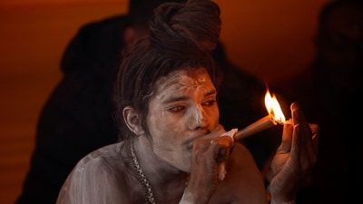 A Naga Sadhu or Hindu holy man smokes inside his tent during the Mahakumbh Mela in Prayagraj (REUTERS)