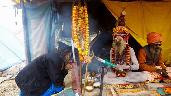 Mahakumbh, day 3: A Naga Sadhu or Hindu holy man blesses a devotee inside his tent during the “Maha Kumbh Mela” in Prayagraj, India, January 15, 2025.(REUTERS)