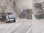 The truck driver was seen climbing out of the overturned vehicle. The truck driver was seen climbing out of the overturned vehicle.