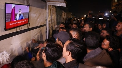 People watch the live television broadcast of a press conference being addressed by Qatar Prime Minister Sheikh Mohammed bin Abdulrahman bin Jassim Al-Thani, along a street in Khan Yunis in the southern Gaza Strip on January 15, 2025. (AFP) People watch the live television broadcast of a press conference being addressed by Qatar Prime Minister Sheikh Mohammed bin Abdulrahman bin Jassim Al-Thani, along a street in Khan Yunis in the southern Gaza Strip on January 15, 2025. (AFP)