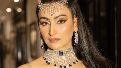 The reality star and art collector dazzles in a metallic Rahul Mishra gown, featuring delicate straps that add a touch of understated elegance. Elevating the look, she adorns a striking Tanzanite choker and a diamond headgear from  RK Jewellers